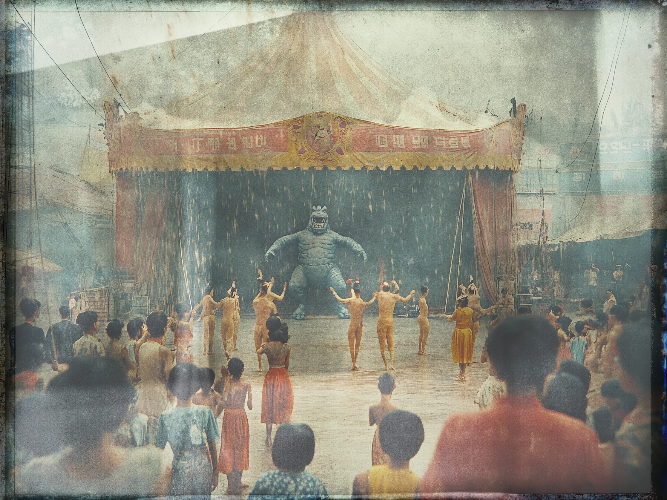 A vintage-style photograph depicts an open-air circus performance with a captivated audience. In the center, a stage is set under a circus tent adorned with a colorful banner featuring unidentifiable writing and a cartoonish animal emblem. Onstage, a large person dressed in a whimsical blue costume resembling a creature stands amidst a group of performers, clad in beige outfits. The performers are engaged in a synchronized dance, arms raised towards the creature. The foreground is filled with spectators, including children, watching the performance keenly. The overall image has a nostalgic, washed-out color palette, adding to its aged appearance.